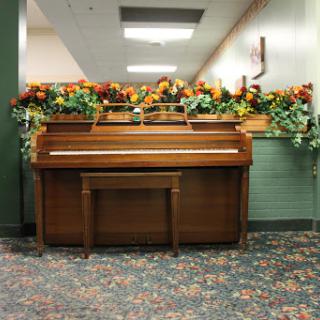 A beautifully decorated piano with floral arrangements in a cozy indoor space.