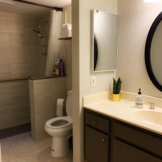 A modern and clean bathroom featuring a shower, toilet, sink, and mirrors.