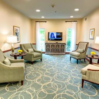 A cozy living room with elegant furniture, a television, and soft lighting.