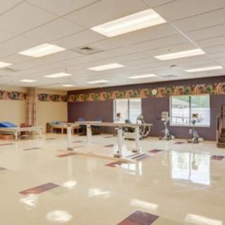 An empty gym room with exercise equipment and bright lighting.