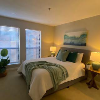 A cozy bedroom featuring a well-made bed, soft lighting, and tasteful decor.