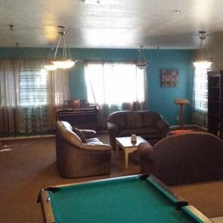 A cozy living room with a pool table and comfortable seating area.