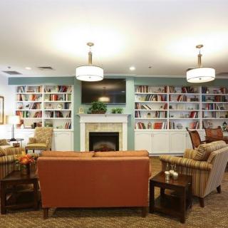 Cozy library interior with comfortable seating and a warm fireplace.