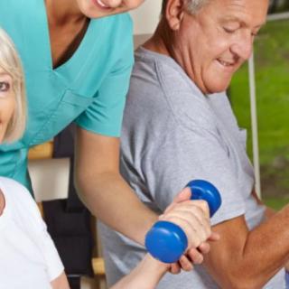 Seniors engage in a guided exercise session using dumbbells, assisted by a healthcare professional.