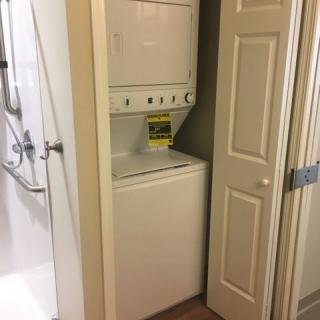 A compact laundry space with a stacked washer and dryer unit.
