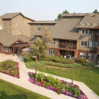 A residential building with a landscaped garden and vibrant flower beds.