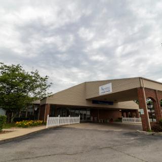 A spacious building with a welcoming entrance under a cloudy sky.