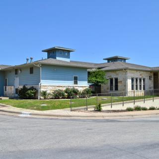 A modern residential building situated in a suburban area on a sunny day.