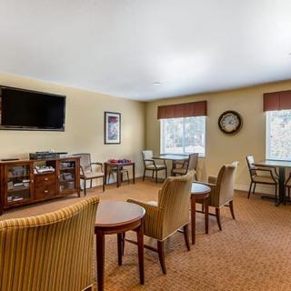 A cozy living room with chairs, tables, and a television.