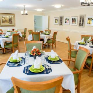 A well-decorated dining room with neatly set tables and chairs, featuring a cozy and inviting atmosphere.