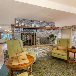 Cozy lounge area with armchairs and a brick wall backdrop.