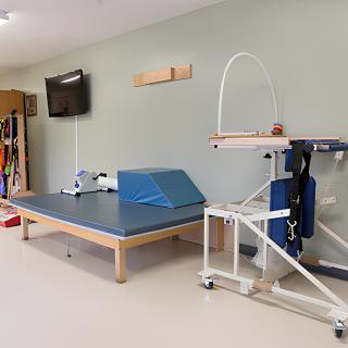 A physical therapy room equipped with exercise equipment and a treatment table.