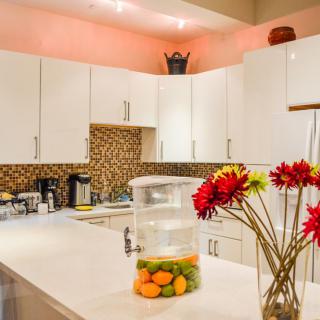 Modern kitchen with white cabinets and stylish decor.