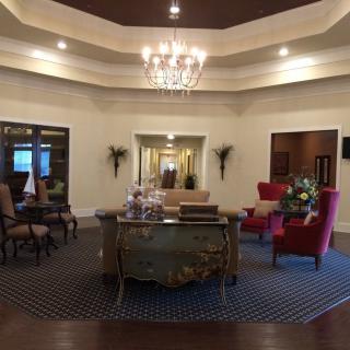 A luxurious lobby with elegant furnishings and a central chandelier.