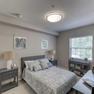 A modern and elegantly decorated bedroom with neutral tones and natural light.