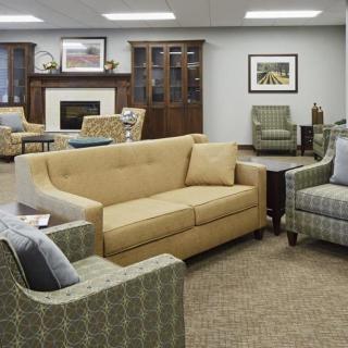 A cozy living room with a sofa, armchairs, and a fireplace.