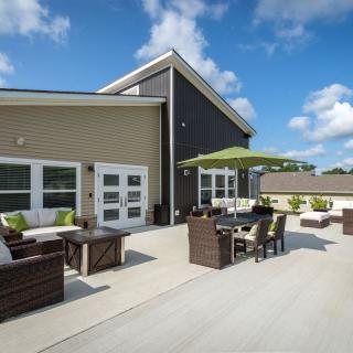 A spacious outdoor patio featuring modern furniture under a sunny sky.