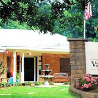 View of a welcoming residential building with landscaped front yard and an American flag.