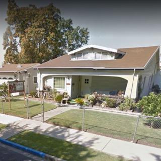 A suburban house with a garden and fenced front yard.