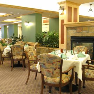 A cozy restaurant dining area with neatly arranged tables and a fireplace.