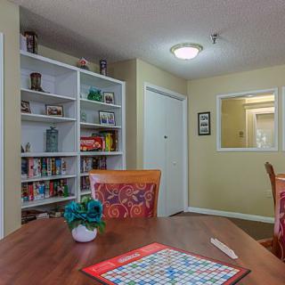A cozy living room with a bookshelf, table, and a game board on display.