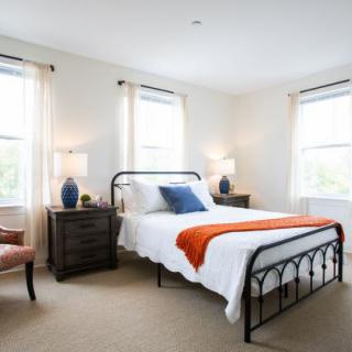 A cozy bedroom with a modern design featuring a metal-framed bed and stylish decor.