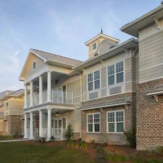 A modern residential building with large windows and a porch.