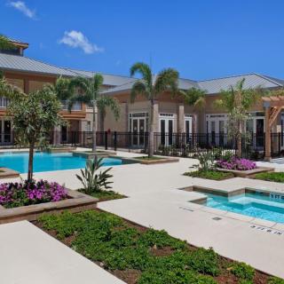 A luxurious tropical resort with a swimming pool and lush landscaping.