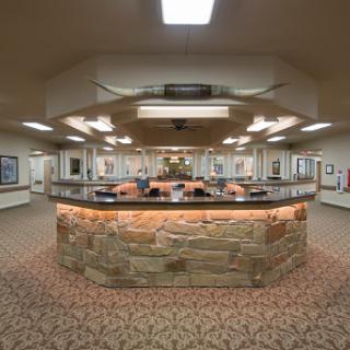 A spacious and elegantly designed reception area with a stone counter, showcasing modern lighting and decorative elements.