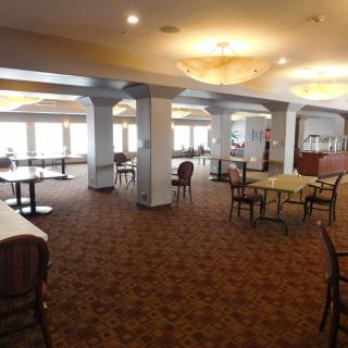 Spacious dining area with elegant lighting and a view through large windows.