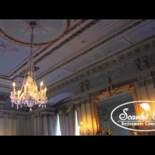 A beautifully ornate ceiling featuring a grand chandelier in an elegant room.