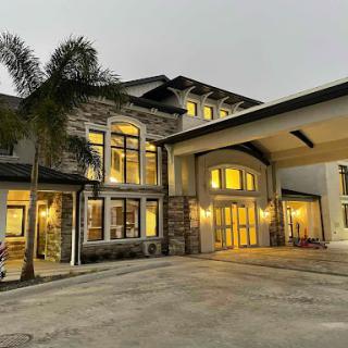 A beautifully designed residential building showcasing modern architecture with warm lighting and palm trees.