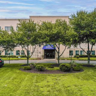 A welcoming hotel entrance surrounded by well-maintained greenery.