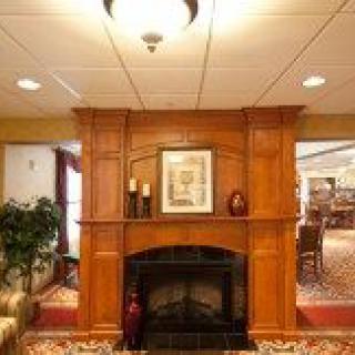 A cozy living room with a wooden fireplace and decorative artwork.