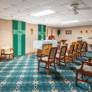 A small chapel with an altar, chairs, and religious decorations.