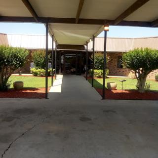 A view of a well-maintained courtyard with a covered pathway and landscaped greenery.