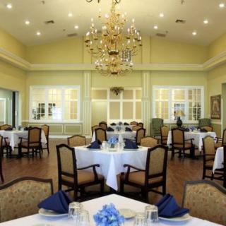 An elegant dining room with neatly arranged tables and a chandelier.