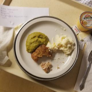 A hospital meal tray featuring mashed potatoes, meatloaf, and peas.