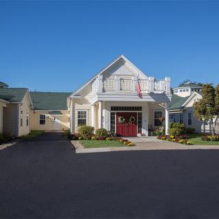 A suburban residential house with a driveway under a clear blue sky.