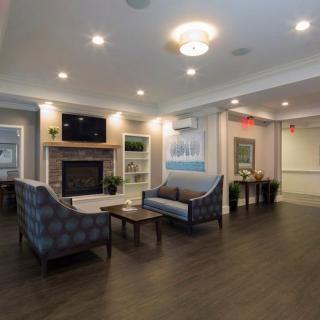 A cozy living room featuring comfortable seating, a fireplace, and a mounted TV.