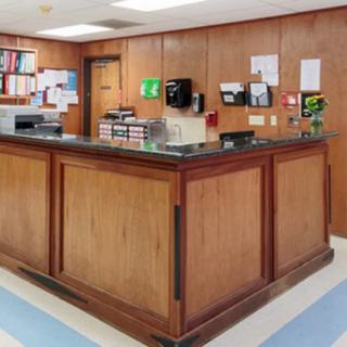 An office reception area with wood paneling and a central desk.