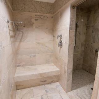 A modern bathroom shower area with tiled walls and a built-in bench.