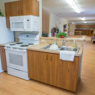 A modern kitchen with wooden cabinets, a stove, and a microwave.