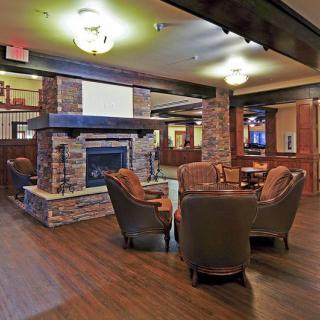 A cozy lounge area featuring a stone fireplace and comfortable seating.