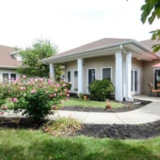 A well-maintained house with a garden and white columns.