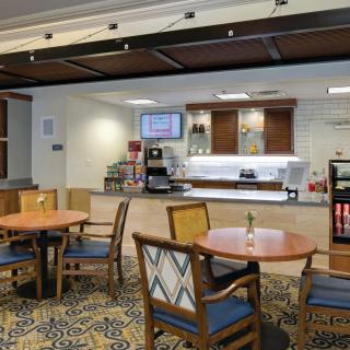 A cozy cafe seating area with tables, chairs, and a coffee station.