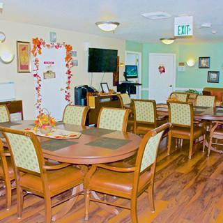 A cozy dining area with autumn-themed decorations and wooden flooring.