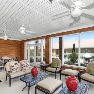 A bright sunroom with comfortable seating and large windows overlooking a patio.