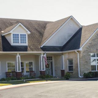 A residential house with a driveway and front porch on a sunny day.