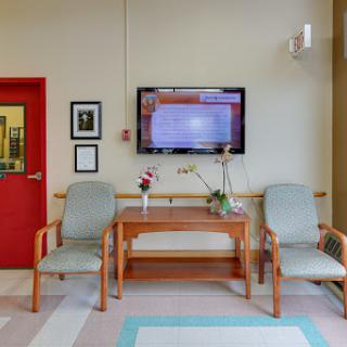 A cozy waiting room featuring comfortable chairs and a television.